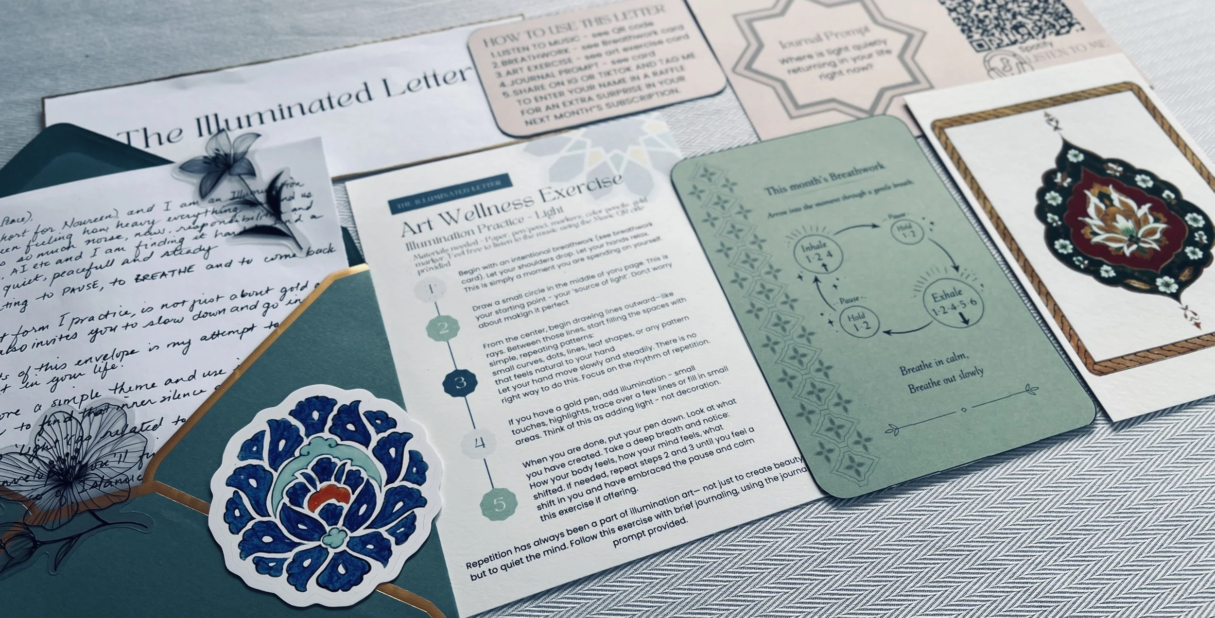 A spread from the Illuminated Letter showing a handwritten note, breathwork card, art wellness exercise card and an original illumination art print.